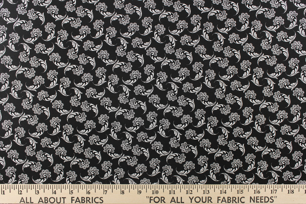  This fabric features a whimsical floral design in white on a black background.