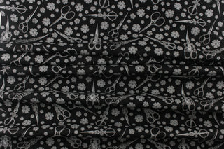  This elegant quilting print features vintage scissors in a mix of different size flowers in white against a black background