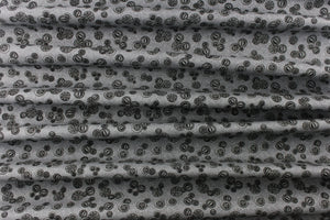 This elegant quilting print features vintage buttons in a black outline/shading in different sizes set against a gray background.