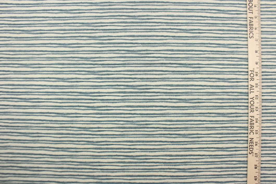  This fabric features brushstroke stripes design in blue against pale beige .