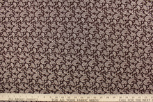 Load image into Gallery viewer,  This fabric features a paisley design in white set against a brown background. 
