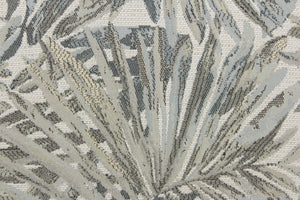 This jacquard fabric features a palm leaf design in gray, pale beige, pale blue and white . 