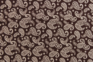  This fabric features a paisley design in white set against a brown background. 