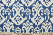 Load image into Gallery viewer, This multi use indoor/outdoor fabric features a distressed medallion design in indigo, cream and tan.  It is perfect for outdoor settings or indoors in a sunny room.  It is stain and water resistant and can withstand up to 500 hours of direct sun exposure.  Uses include decorative pillows, cushions, chair pads, tote bags and upholstery.  
