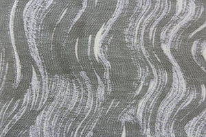 This jacquard features a vertical wavy design in gray and sliver with hints of pale purple. 