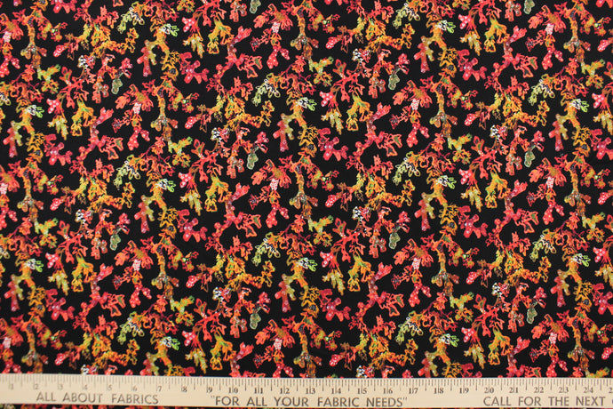 This fabric features sea coral design in orange, green, dark pink, peach, brown, and white set against a black background.