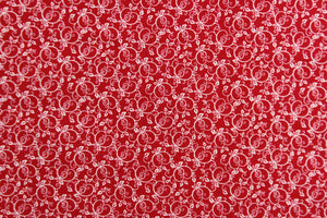 This fabric features a tiny floral vine design in white set against a red background. 