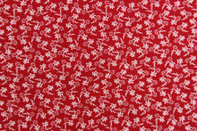Load image into Gallery viewer,  This fabric features a tiny floral design in white set against a red background. 
