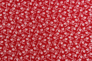  This fabric features a tiny floral design in white set against a red background. 