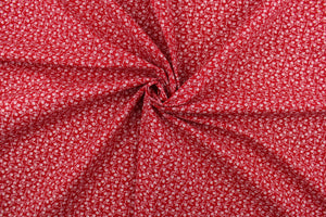  This fabric features a tiny floral design in white set against a red background. 