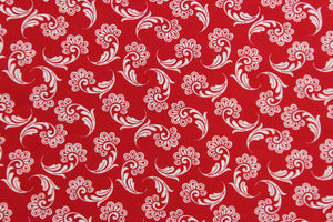 This fabric features a whimsical floral design in white on a red background. 