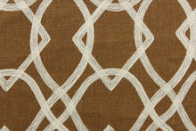 Load image into Gallery viewer, This jacquard features a geometric design of diamonds and ovals in a off white set against a dark golden tan .
