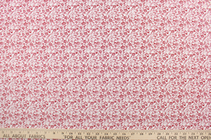 This fabric features a whimsical floral design in red set against a white background.
