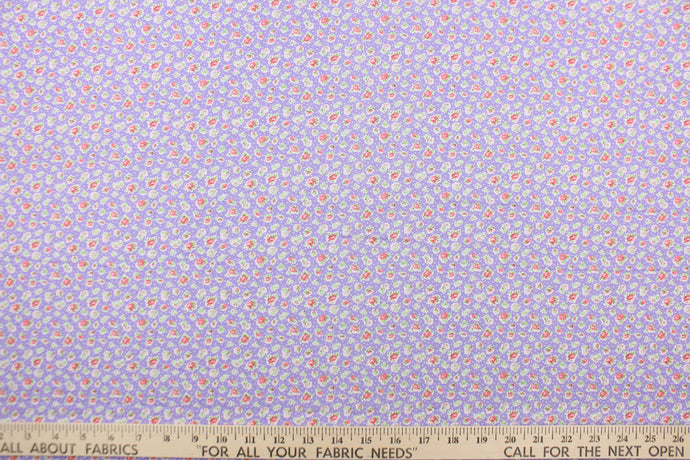  This fabric features a tiny floral design in pink, pale gray, white and green set against a light purple background.