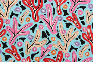  A whimsical design in in pink, nude, red, purple, orange, black, and white, set against a blue background . 