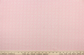 This fabric features a tiny floral design in pink and  green set against a white background.