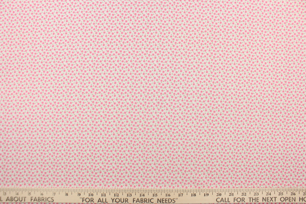 This fabric features a tiny floral design in pink and  green set against a white background.