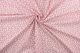 This fabric features a tiny floral design in red set against a white background.
