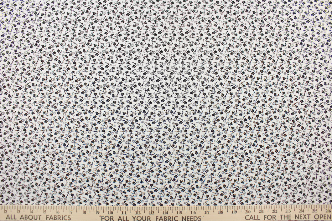  This fabric features a tiny floral design in black set against a white background.