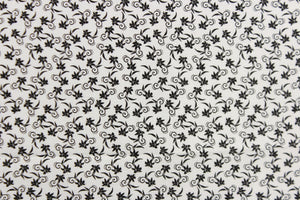  This fabric features a tiny floral design in black set against a white background.