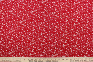  This fabric features a  floral design in white set against a red background. 