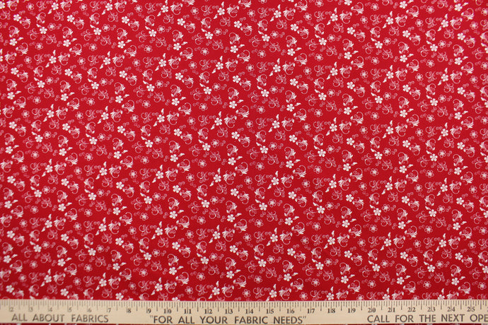  This fabric features a  floral design in white set against a red background. 