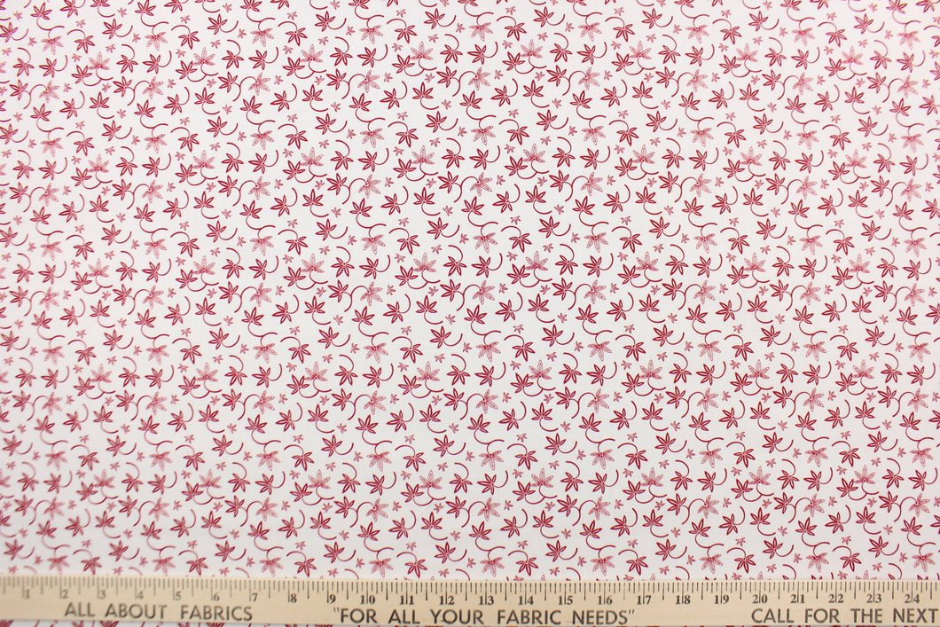 This fabric features a  floral design in red set against a white background.