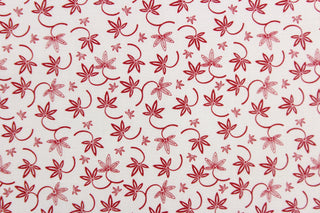 This fabric features a  floral design in red set against a white background.