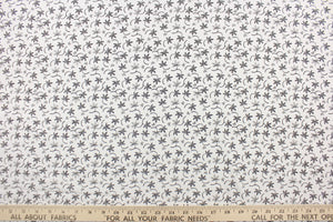 This fabric features a  floral design in black set against a white background. 