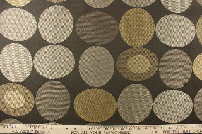 Geometric pattern of circles and ovals in gold and pewter tones on a brown gray background