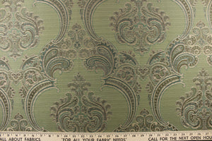 ornamental damask design in varying shades of green and hints of light gold on a green background