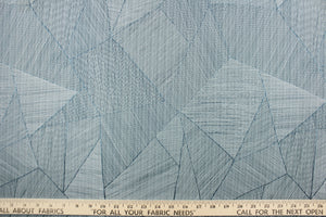  This jacquard features a geometric design in varying shades of blue .