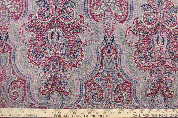 This tapestry fabric features a vibrant demask design in light purple, blue, taupe and burgundy purple .