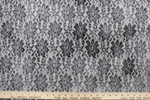 This lace features a woven floral design in gray with a white outline.