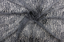 Load image into Gallery viewer, This lace features a woven floral design in gray with a white outline.
