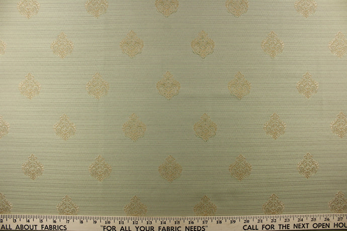 Ornamental damask medallion with hints of champagne or light gold on a pale green background