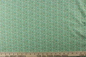 This fabric features a dainty floral design in pale green  with orange, blue and white flowers 
