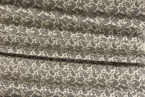 A fun paisley design in basic colors of  black set against a cream background. 