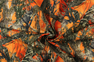 : This outdoor canvas features a realistic maximum concealment camouflage design against a orange background.