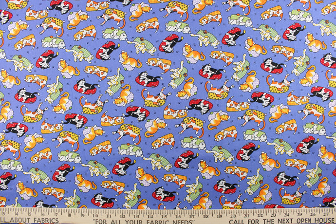 This quilting print features your typical household pets of dogs and cats lounging around in their beds in orange, white, black, red, green, yellow, and pale purple against a blue background. 