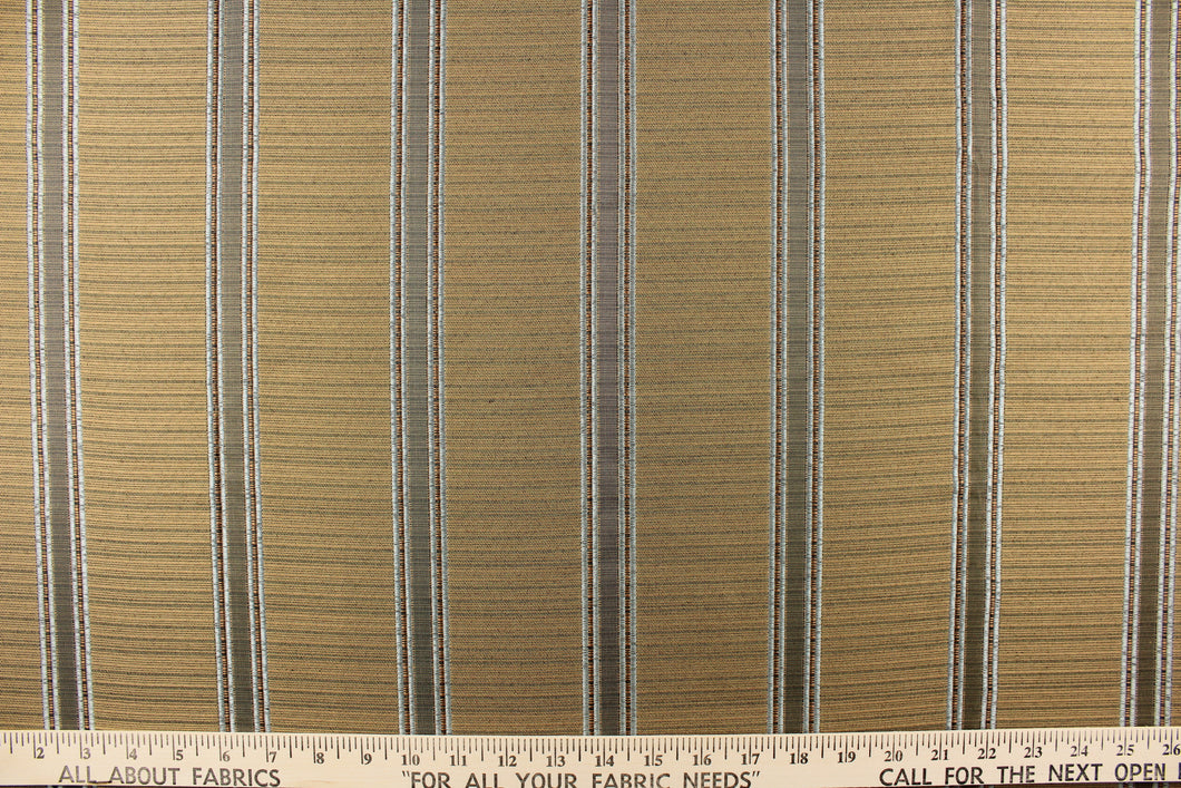 This rich woven yarn dyed fabric features bold multi width striped pattern in a pale blue, brown and gold colors. 