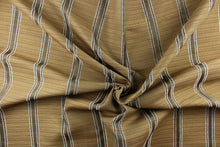 Load image into Gallery viewer, This rich woven yarn dyed fabric features bold multi width striped pattern in a pale blue, brown and gold colors. 
