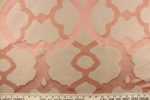 This light weight Jacquard fabric features a geometric scroll design on a silken background in tones of Coral. 