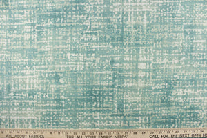 This fabric features a blot/ water color design in a pale teal blue and white with hints of gray. 