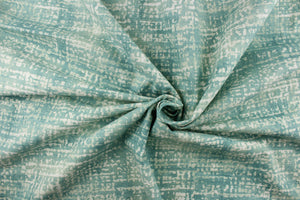 This fabric features a blot/ water color design in a pale teal blue and white with hints of gray. 