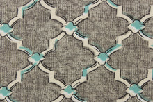 Load image into Gallery viewer, This fabric features a geometric design in white, off white and pale teal blue outlined in black against a gray background. 
