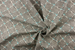 This fabric features a geometric design in white, off white and pale teal blue outlined in black against a gray background. 