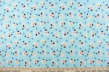 Load image into Gallery viewer, This cute quilting print features a white dog with black ears and different colored collars mix in with blue paw prints on a pale blue background. 
