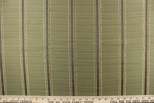 Load image into Gallery viewer, This rich woven yarn dyed fabric features bold striped pattern in light gold, green and brown against a olive green.
