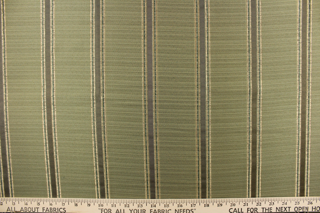 This rich woven yarn dyed fabric features bold striped pattern in light gold, green and brown against a olive green.